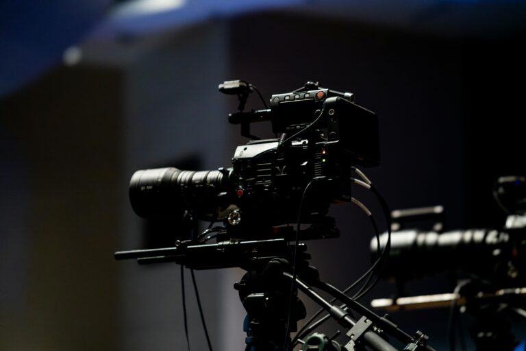 High-quality professional video camera with equipment setup in a dimly lit studio setting.